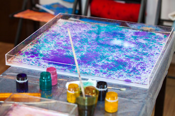 Ebru marbling on water surface in basin