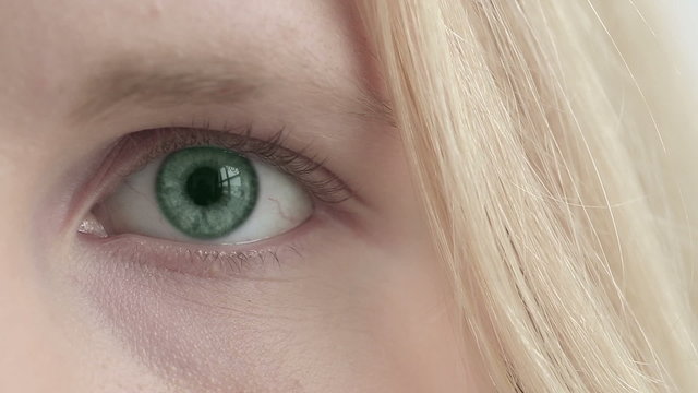 Eye of blonde girl changes color. Close up