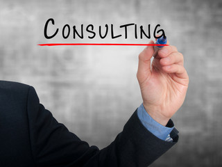 Businessman hand writing Consulting. Grey background.