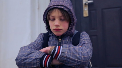 Caucasian boy near the building of the village school.