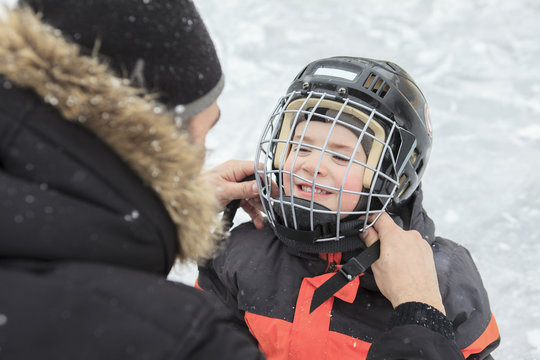 A Family Playing At The Skating Rink In Winter.