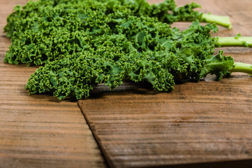 Green curly kale leaves on table