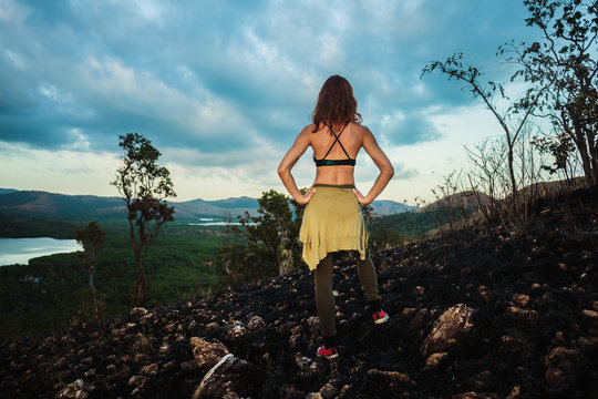 Woman standing on a scorched hill in a tropical climate