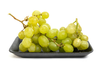 Green grape in black styrofoam with isolated white background