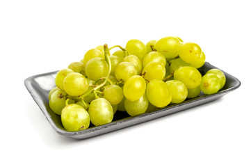 Green grape in black styrofoam with isolated white background