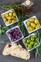 Selection of fresh olives with herbs and oil from above