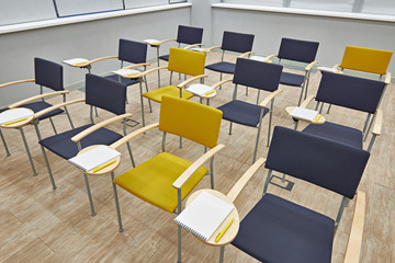 Chairs with notepads in empty classroom