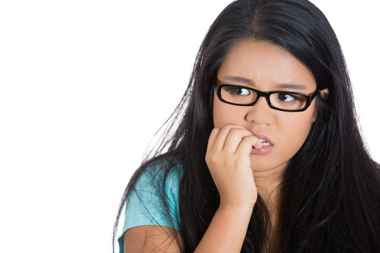 Scared anxious young woman biting fingernails white background 