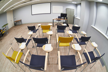 Empty classroom with сhairs and notepads
