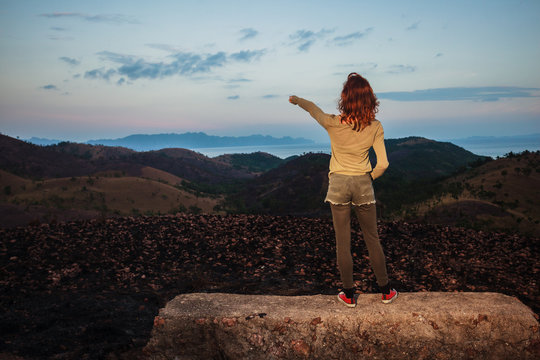 Woman standing on a rock is pointing