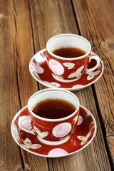 Two cups of black tea with wooden background