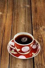 Cup of black tea with wooden space background