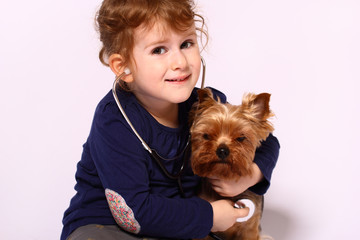 Little girl playing doctor with a dog
