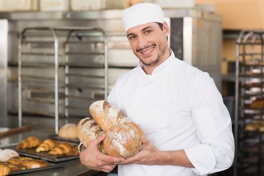 Baker holding freshly baked loaves