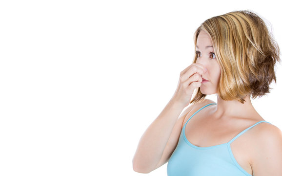 Portrait young woman pinches her nose very bad smell