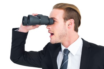 Surprised businessman looking through binoculars