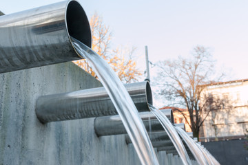 Water flowing out from steel pipes - obrazy, fototapety, plakaty