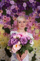 blond woman holding flowers, looking up, short haircut