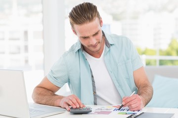 Casual businessman working with calculator