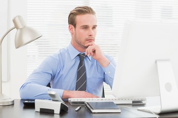 Naklejka premium Businessman thinking with hand on chin