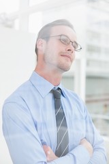 Fototapeta premium Thoughtful businessman standing with arms crossed