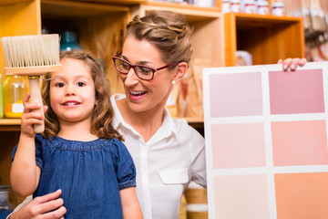 Familie mit Musterkarte für Farben im Laden
