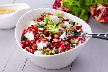 Healthy salad with pomegranate seeds, almond, feta cheese and