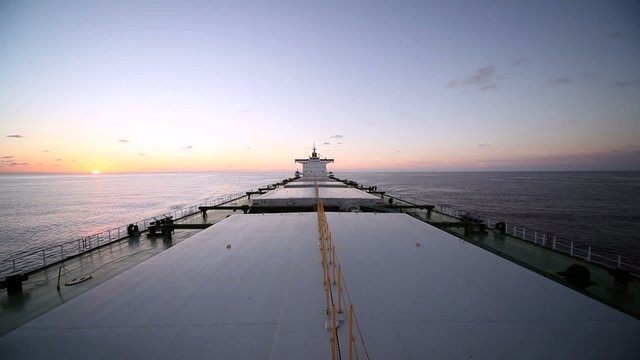 Bulk carrier ship underway at sunset