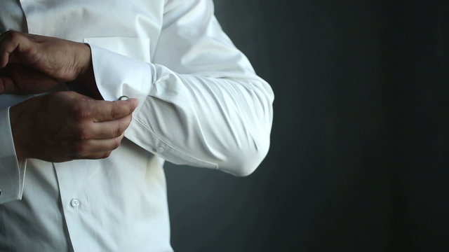 The man wears white shirt and cufflinks