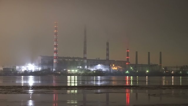 Panorama of electricity plant in fog by a river while the night