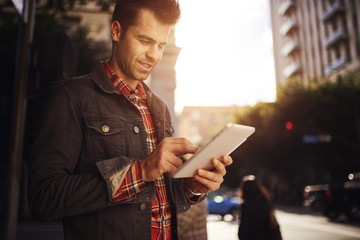 man using tablet on street in down town los angeles