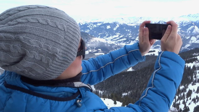 Young woman uses a smartphone to video a beautiful view