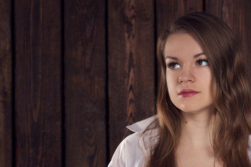 Fototapeta na wymiar Portrait of a girl on wooden wall