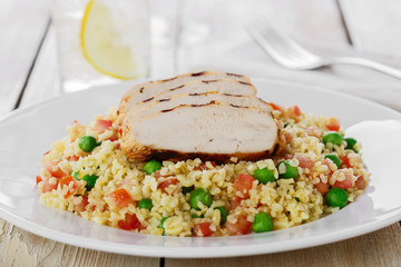 couscous with green peas and chicken fillet grill