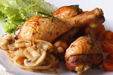 Baked chicken drumsticks with mushrooms. Horizontal close-up