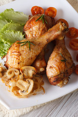 Baked chicken drumsticks with mushrooms vertical top view