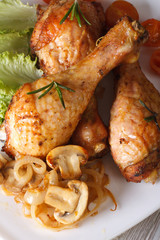 chicken drumsticks with mushrooms and rosemary vertical top view