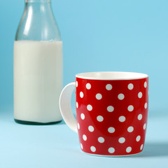 Still life with red cup of milk and antique bottle of milk