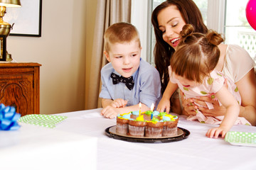 Young family enjoying birthday candles