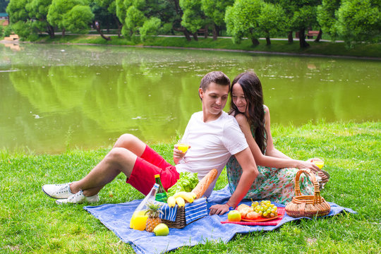 Young happy couple picnicking outdoors