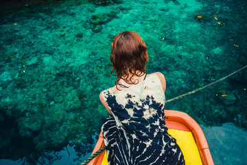 Woman on boat looking at clear blue water