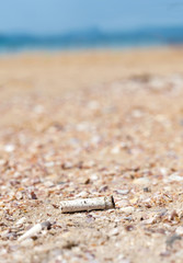 Cigarette butt discarded left on beach, concept photo.