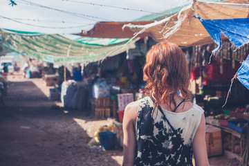 Young woman walking in a small town in developing country - obrazy, fototapety, plakaty