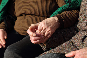 Coppia di anziani che si tengono per mano in segno d'amore