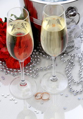Two golden wedding rings, champagne glasses