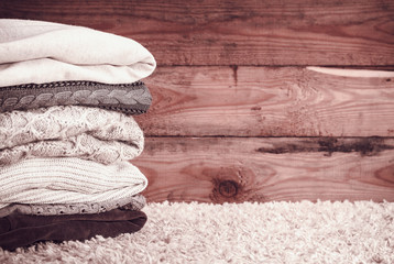 stack of sweaters on a wooden background. vintage toning