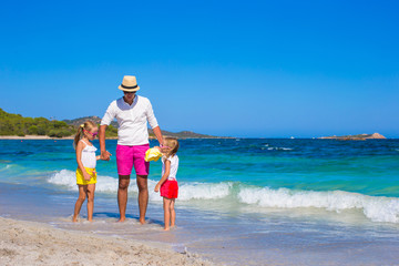 Little girls and happy dad having fun during tropical vacation