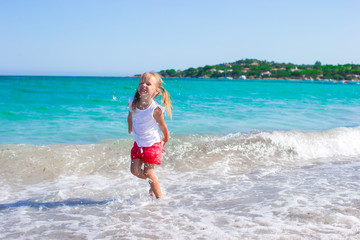 Adorable little girl having fun during tropical beach vacation