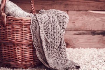 Fototapeta na wymiar knitted fabric in a basket on a wooden background.vintage toning