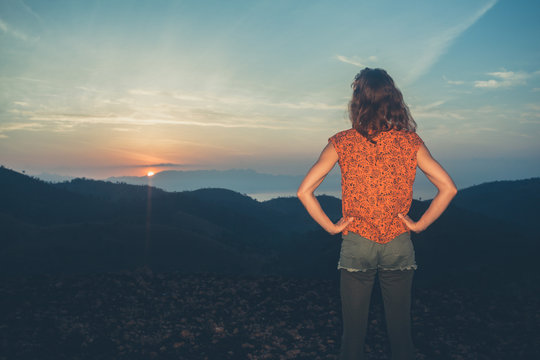 Woman watching sunrise over mountains